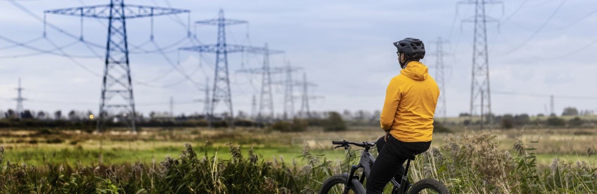 Man on bike looking out at pylons