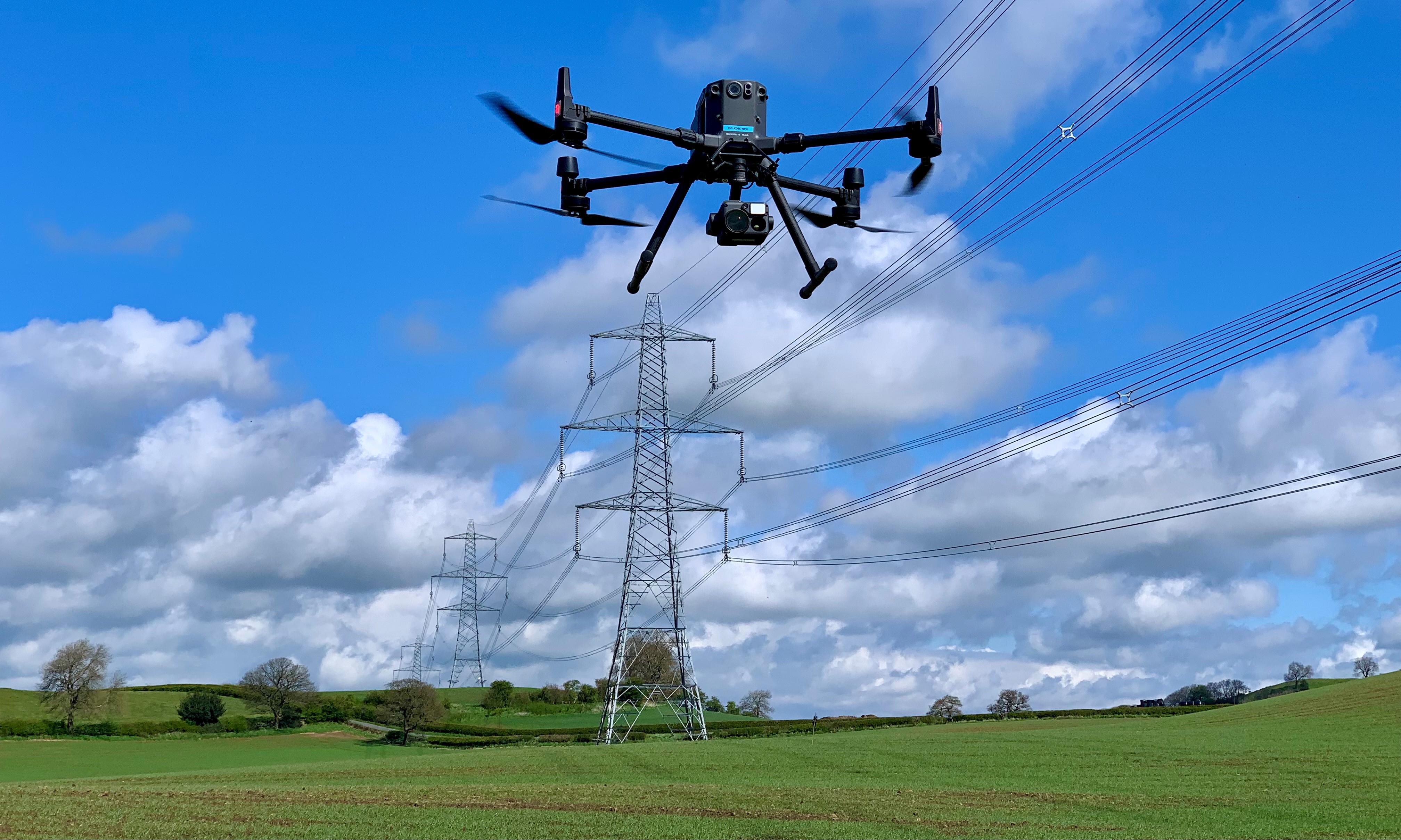 A drone being used by National Grid to inspect a pylon and power lines