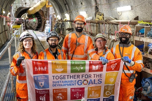 People wearing PPE in a tunnel holding up a banner with National Grid's Sustainable Development Goals
