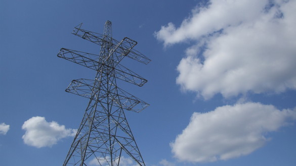 A high angle view of an electricity pylon against a blue and cloudy sky 