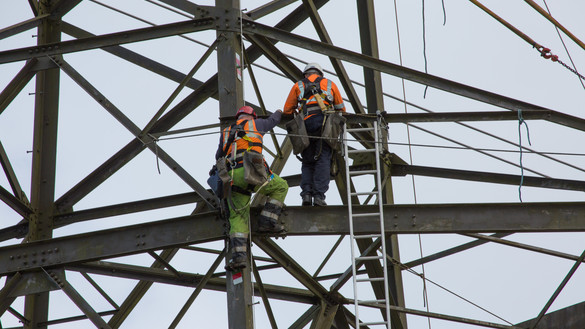 Two National Grid workers climbing onto a steel framework - Swansea to Pembroke