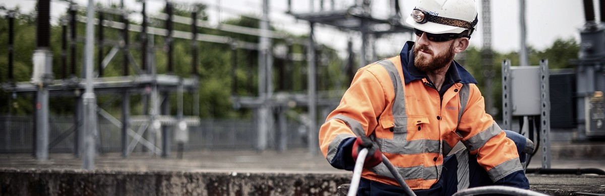 National Grid engineer wearing PPE laying cable at a substation