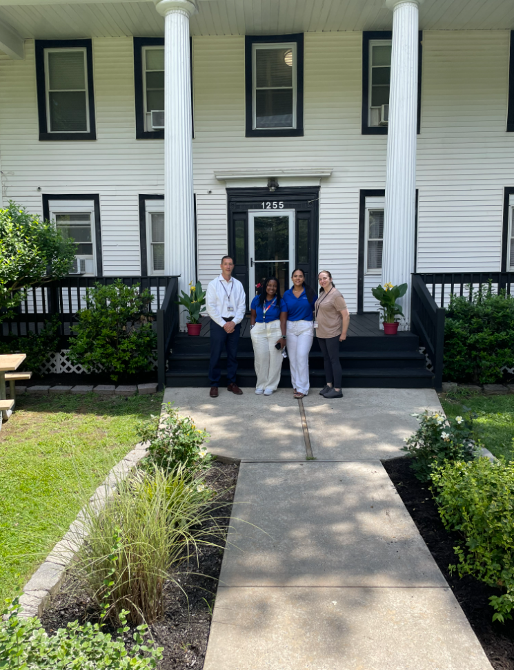 4 people Standing ahead of a Building