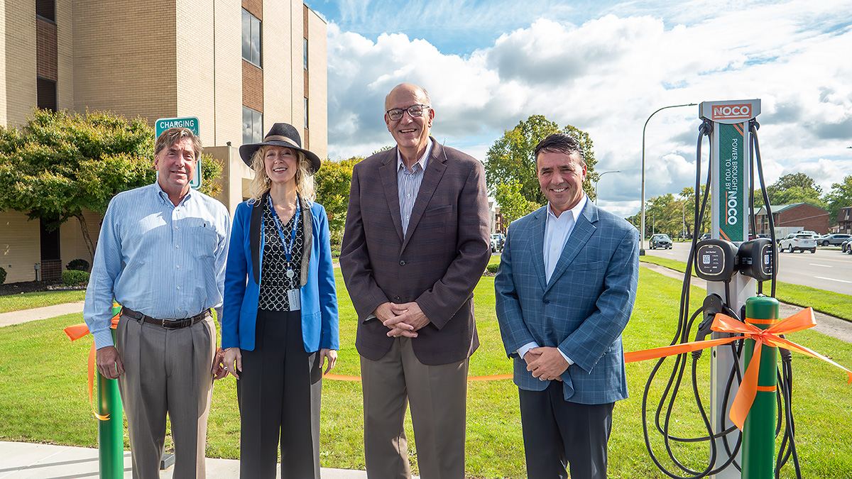4 people Standing ahead of a Building