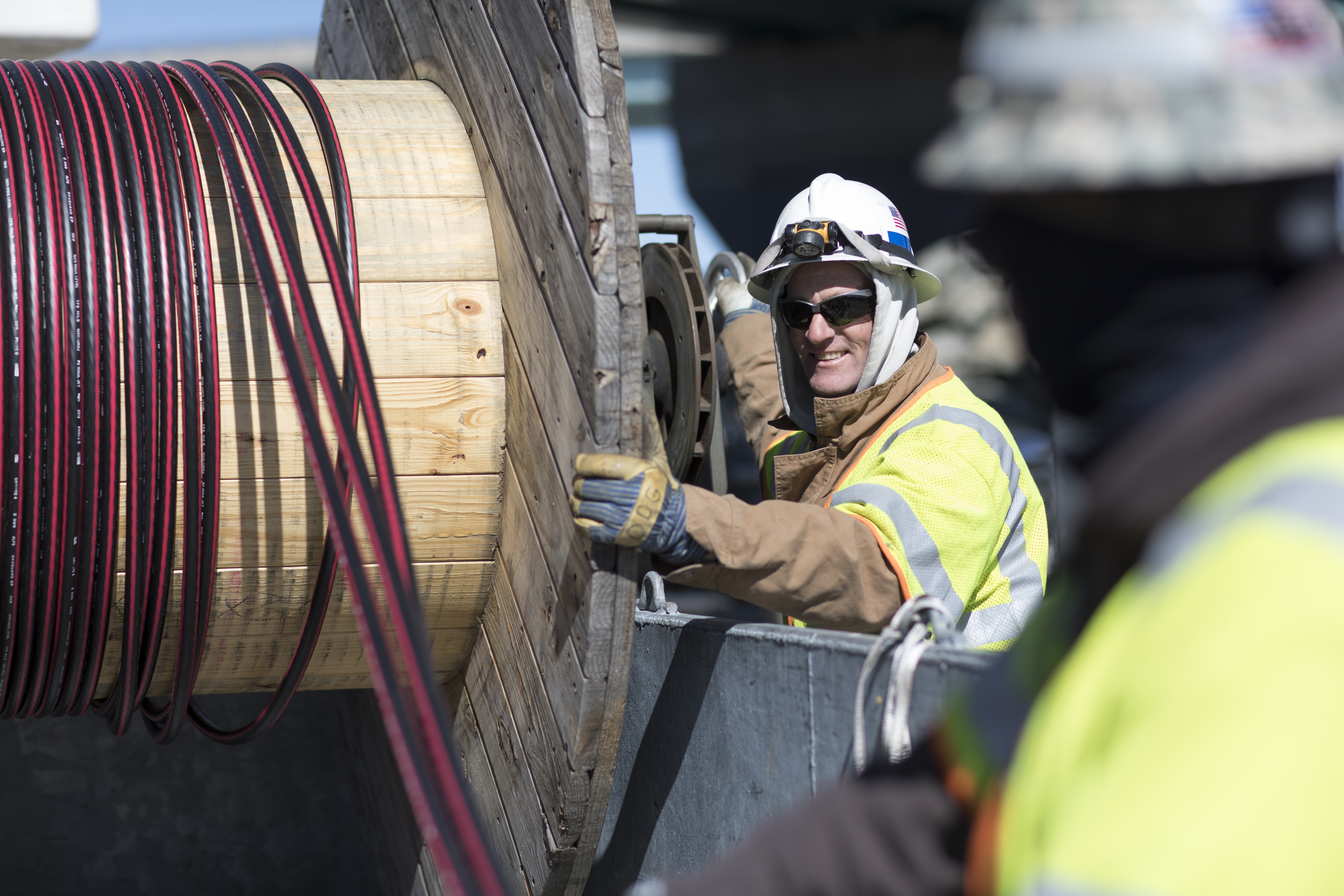 Crew members handling power line Cable