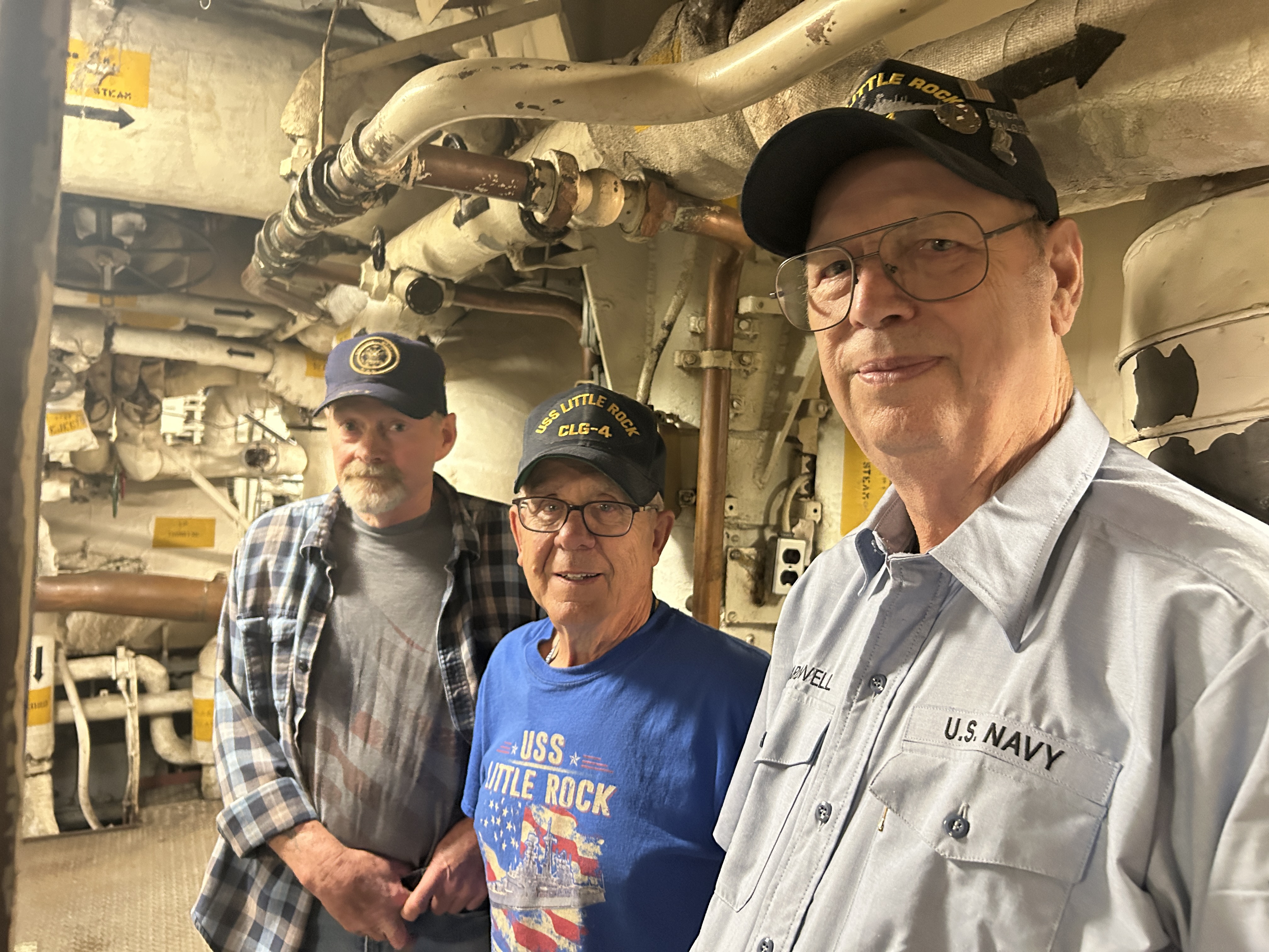Dennis Yerkes, John Landwehr and Wallace Cardwell all served on the USS Little Rock and return each year to volunteer with ship maintenance. They took time from working in the newly lit engine room to discuss their friendship and share memories.  