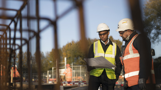 Two men wearing PPE on construction site for National Grid 'Can we achieve carbon-neutral construction by 2026?' story