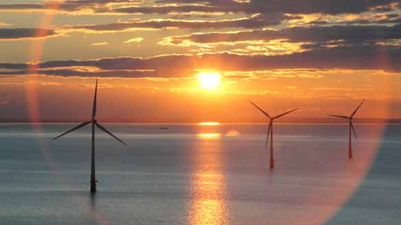 Wind turbines at sea against a beautiful sunset