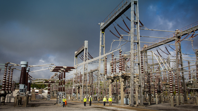 Engineers wearing PPE walking through an electricity substation