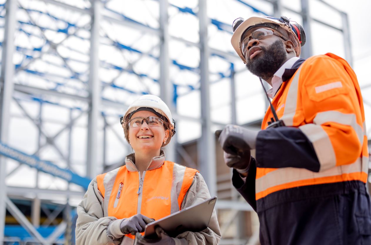 Female and male workers in hard hats