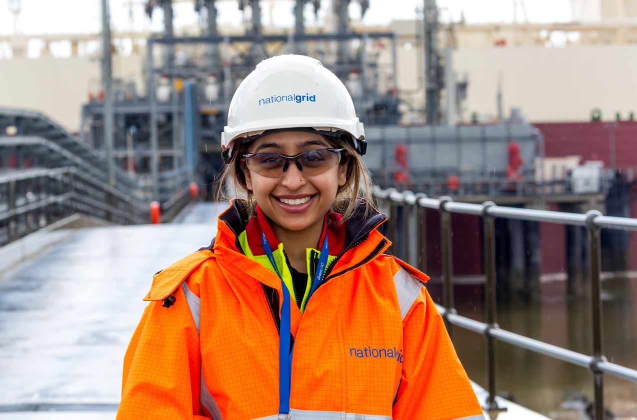 Female worker smiling in a hard hat