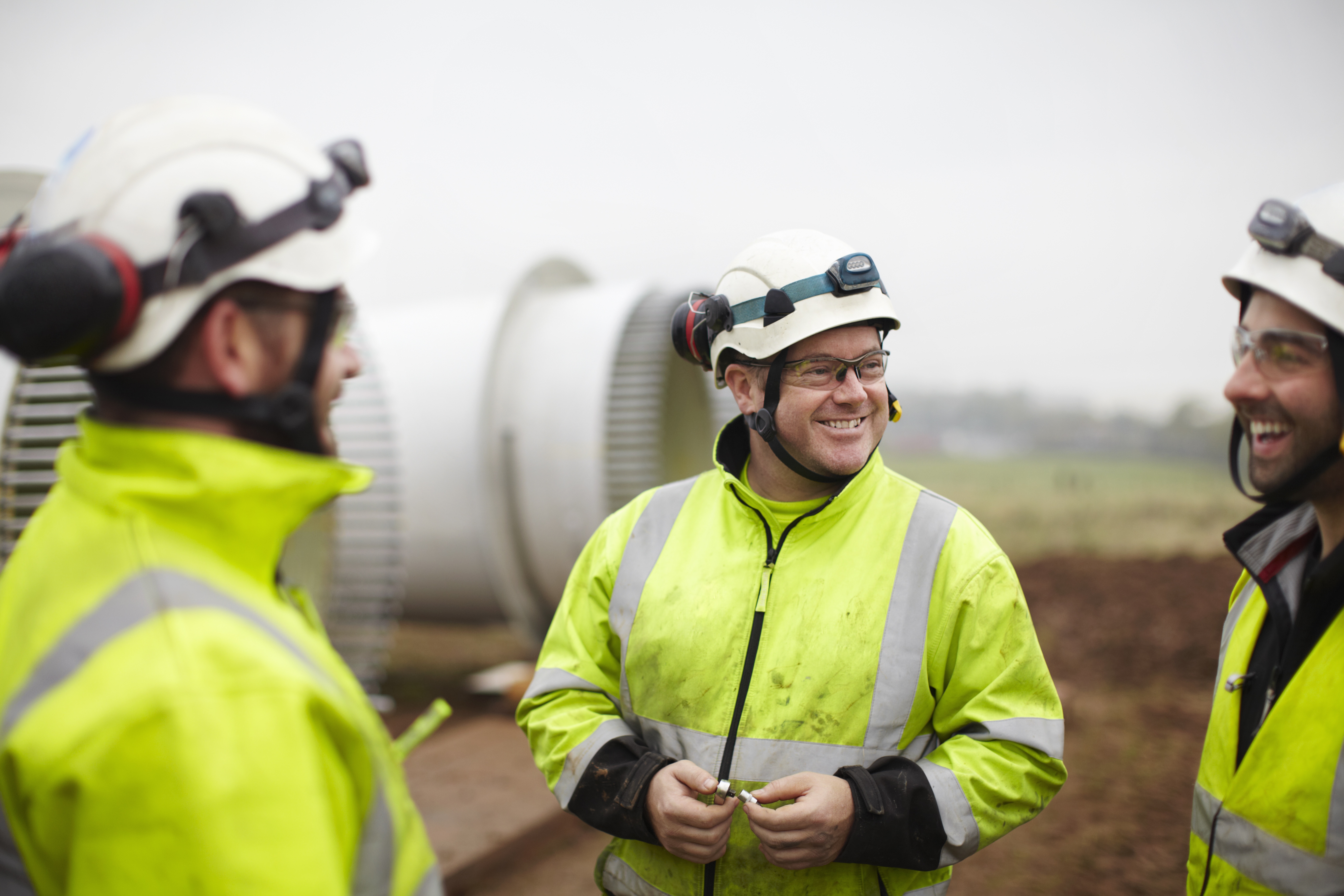 group of engineers in front of a wind turbine