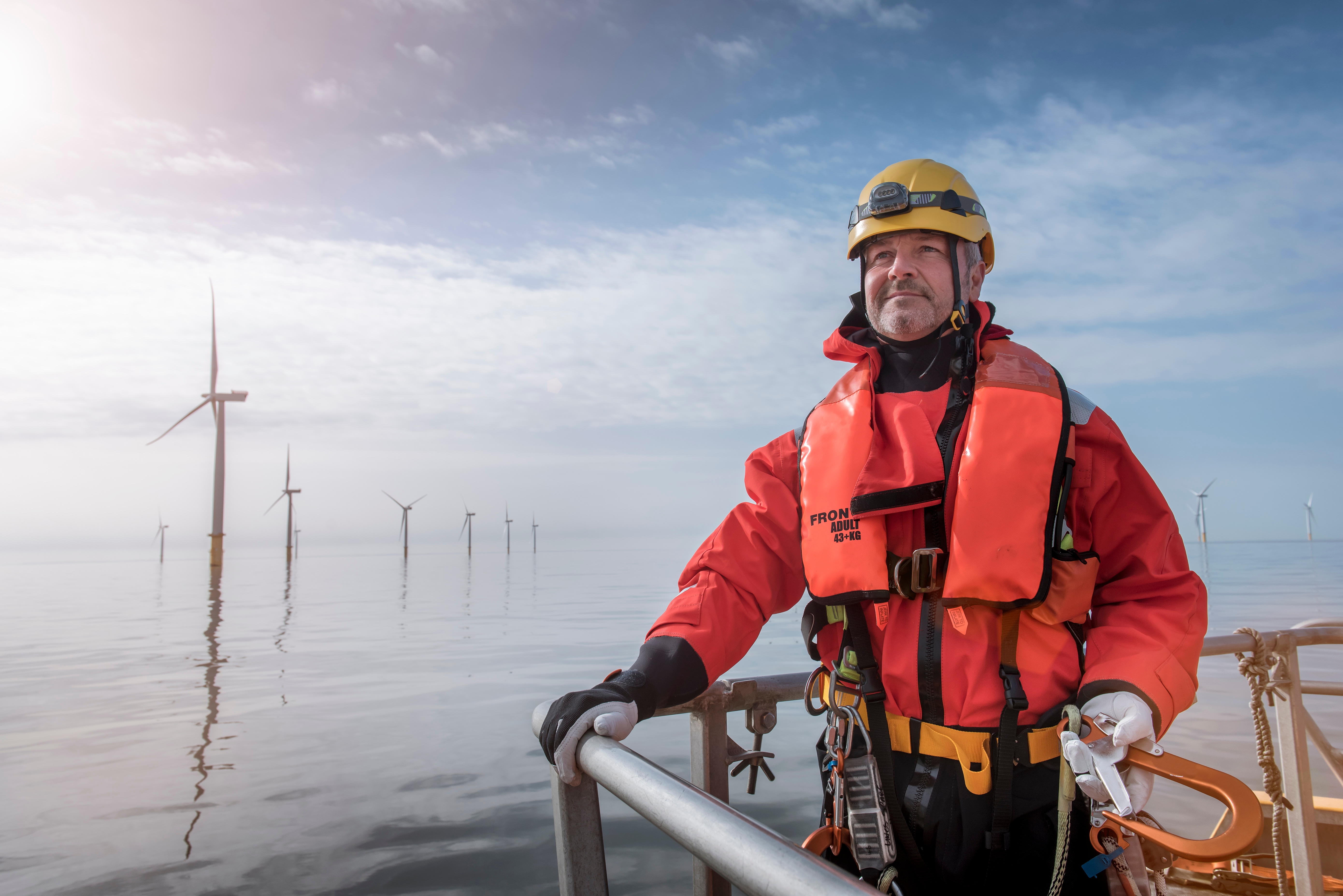 Engineer dramatically in front of an offshore wind farm