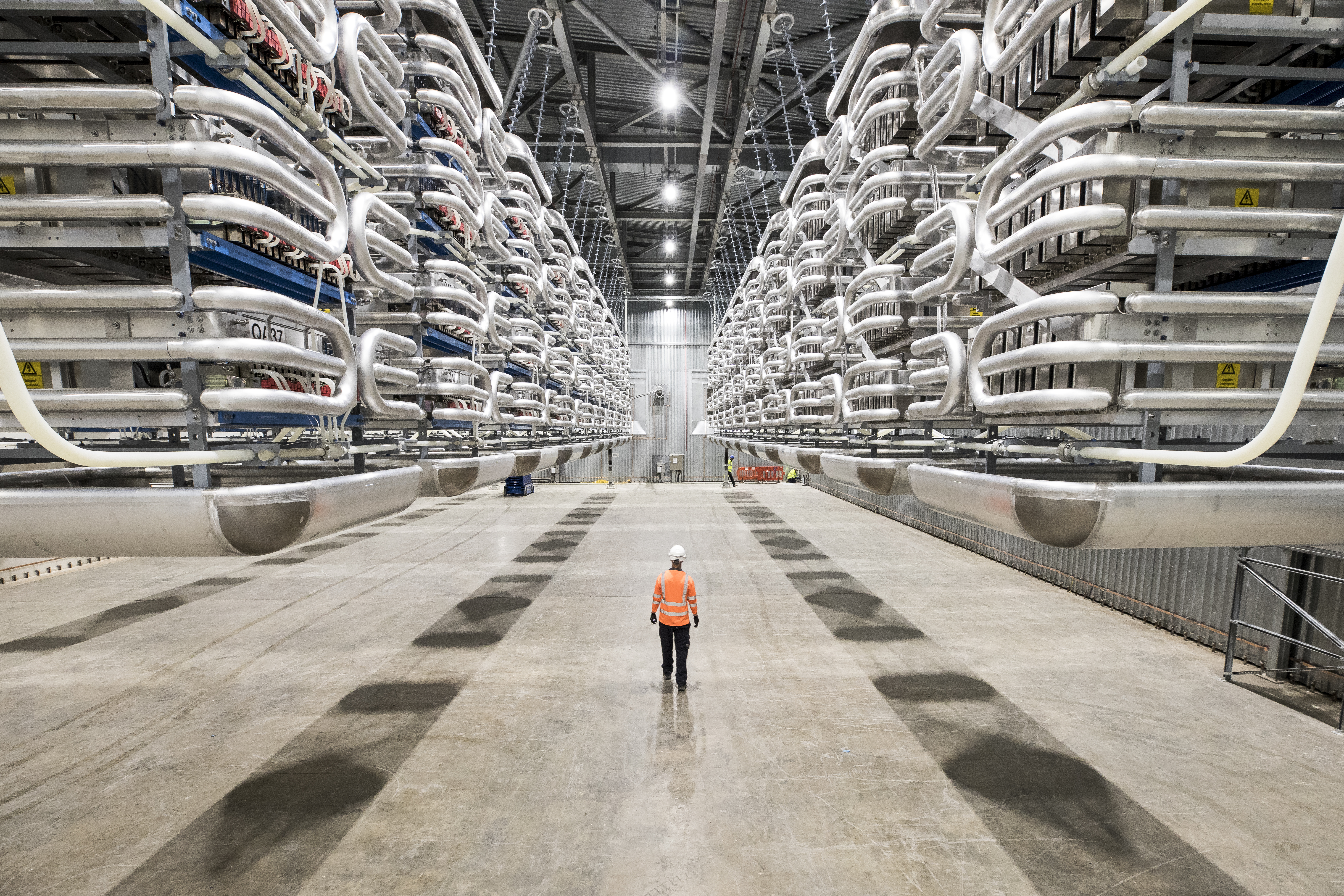 Engineer wearing PPE standing in the valve hall of the IFA2 interconnector