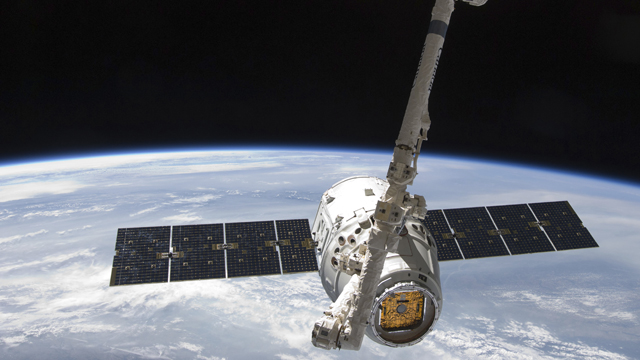 Space X Dragon satellite orbiting earth