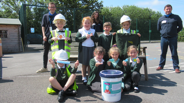 Group of school children preparing a time-capsule to put inside a T-pylon