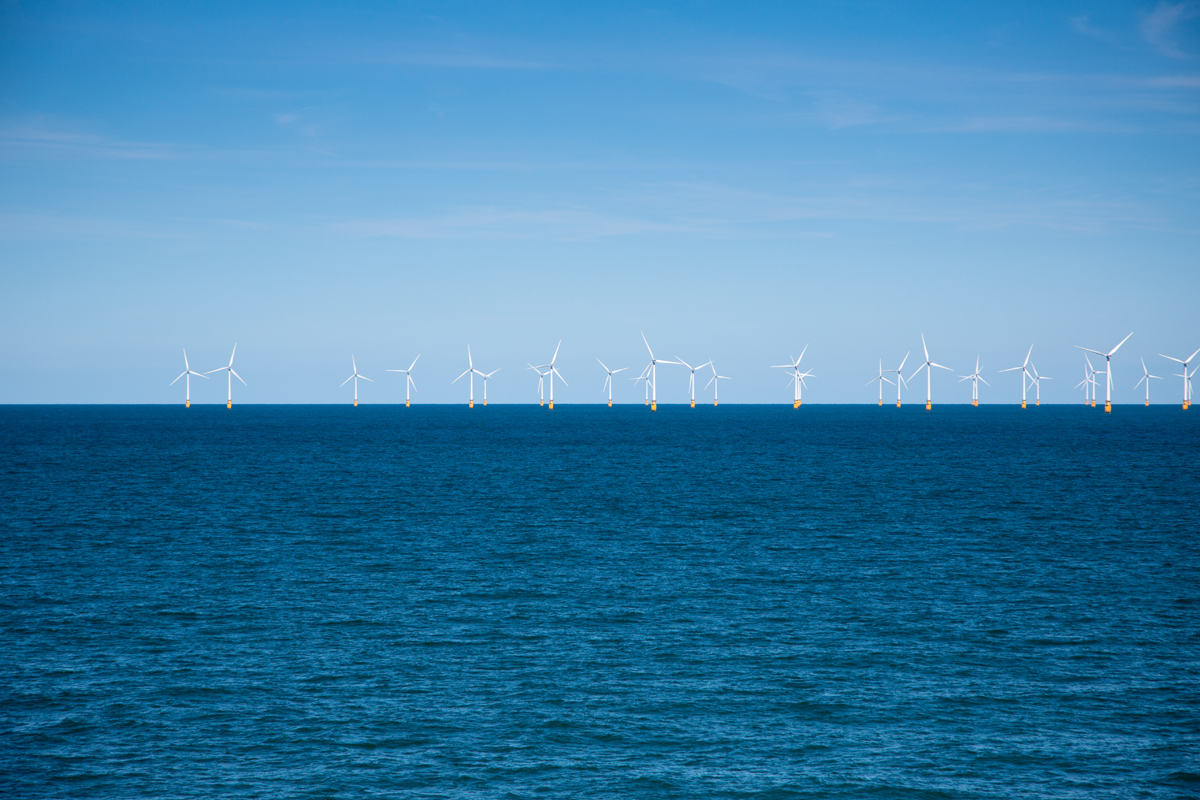 Wind farm in the distance at sea for National Grid 'Green loan speeds race to net zero' story