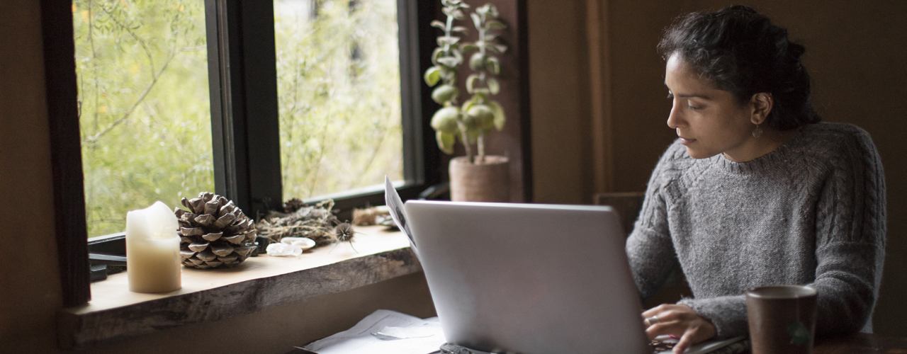 Woman working on a laptop in front of a window - used for the National Grid story 'Looking after our people in uncertain times'