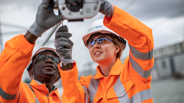 Two National Grid engineers wearing full PPE working on electrical equipment