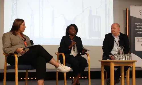 Three people speaking at a conference