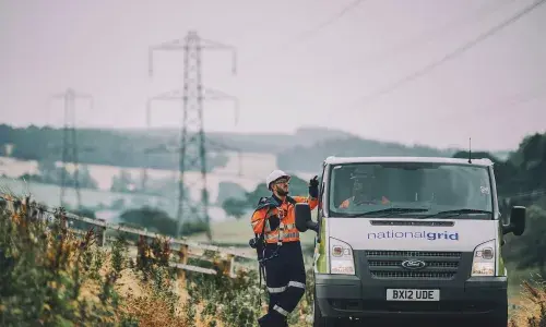 Van on road with pylons in distance