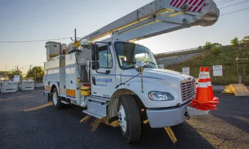 A National Grid truck parked in a Massachusetts facility utility work yard, ready to respond to potential storm damage.