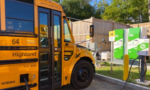 Yellow electric school bus at charging station in Beverly, Massachusetts