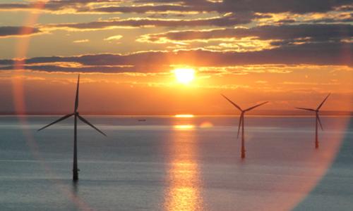Wind turbines at sea against a beautiful sunset