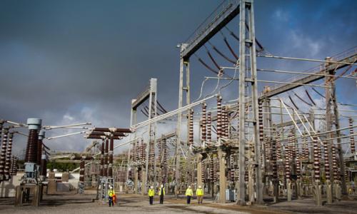 Engineers wearing PPE walking through an electricity substation
