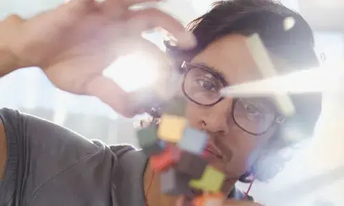 Man holding prototype of coloured cubes used for National Grid article about UK's economic recovery