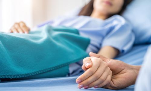 Holding hands with hospital patient for National Grid story 'Supporting carers during stressful times'