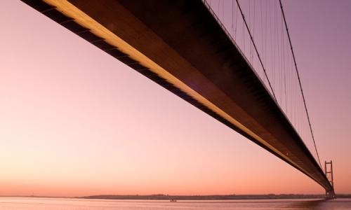 The Humber Bridge seen from below against a pink sky