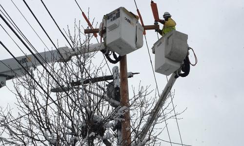 National Grid lineworker fixing a power line in the snow in the US