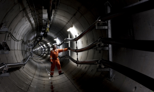 National Grid engineer inspecting the inside of a metallic tunnel structure 