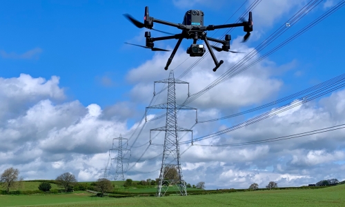Drone inspecting high-voltage overhead power lines