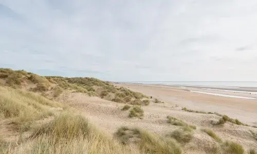 View over beach sand dunes into ocean