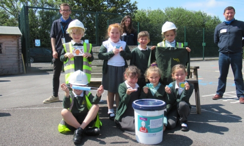 Group of school children preparing a time-capsule to put inside a T-pylon