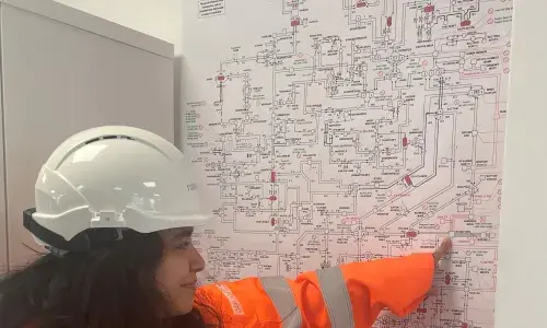 National Grid's Tanya Bukhari wearing PPE and pointing at a diagram on the wall