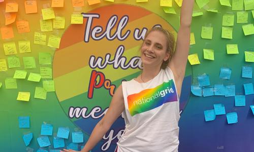 National Grid Pride colleague in front of colourful board with posters