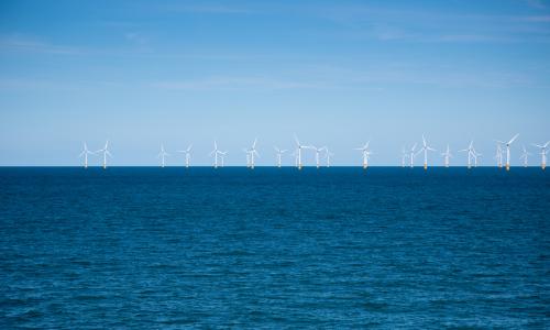 Wind farm in the distance at sea for National Grid 'Green loan speeds race to net zero' story