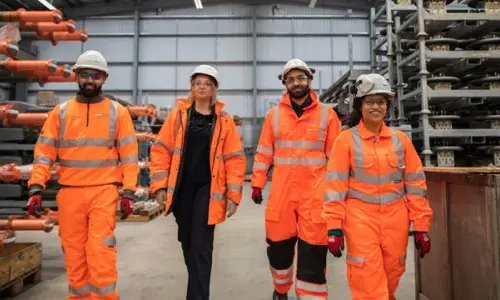 National Grid colleagues wearing PPE walking together in a warehouse