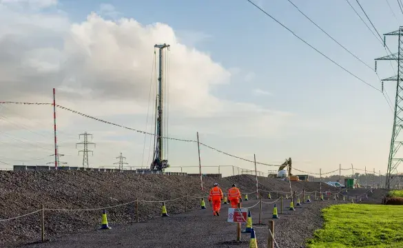 Two people walking down stone path near pylons