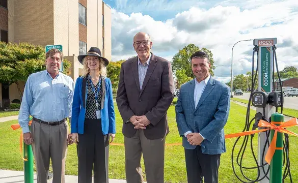 4 people Standing ahead of a Building