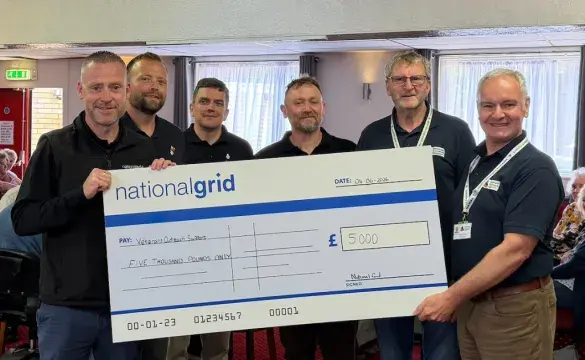 An image showing NGV and Veterans Outreach Support staff with a cheque at the donation handover.