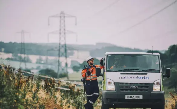 Van on road with pylons in distance