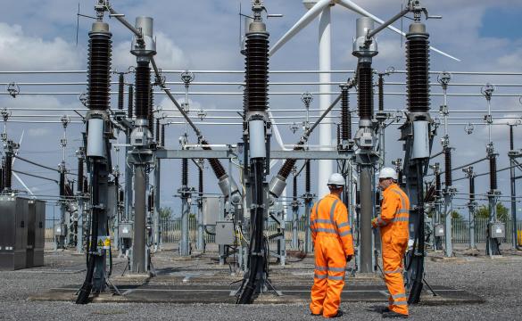 Two engineers wearing orange high-vis overalls and hard hats at Bicker Fenn Substation