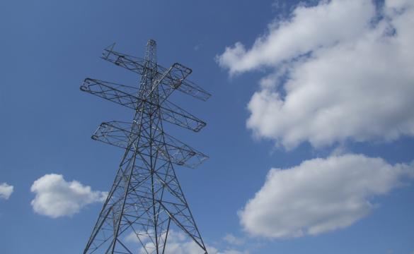 A high angle view of an electricity pylon against a blue and cloudy sky 