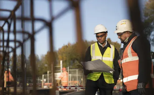 Two men wearing PPE on construction site for National Grid 'Can we achieve carbon-neutral construction by 2026?' story