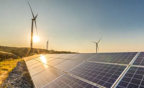 Solar panels and wind turbines at sunrise