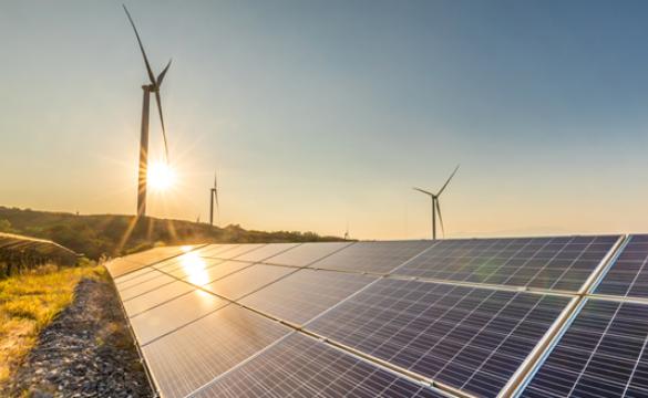 Solar panels and wind turbines at sunrise